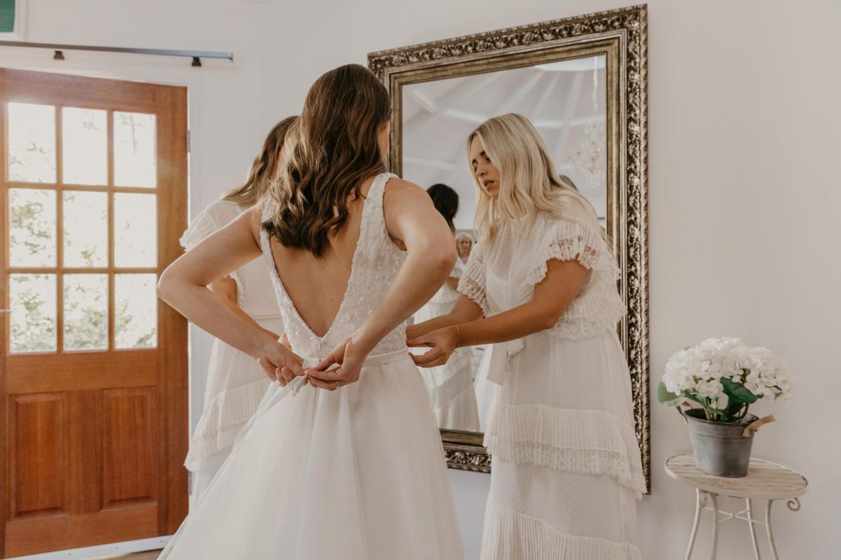 Leah getting ready for wedding with her bridesmaids; wearing the FONTANNE gown by Karen Willis Holmes.