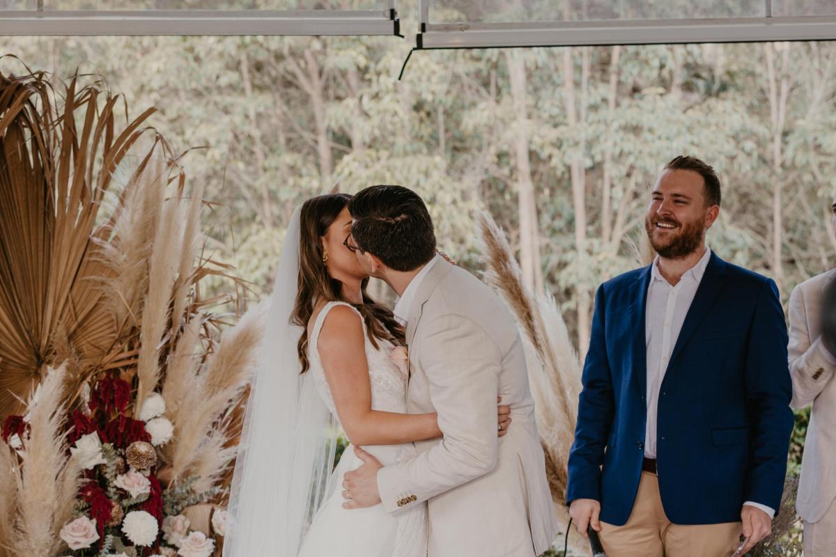 KWH bride Leah and husband Sam kiss at wedding ceremony.