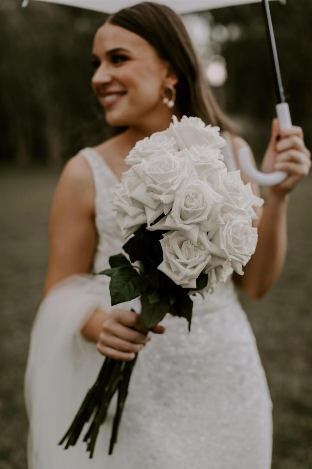 KWH bride Jemma holding her bridal bouquet, featuring white roses