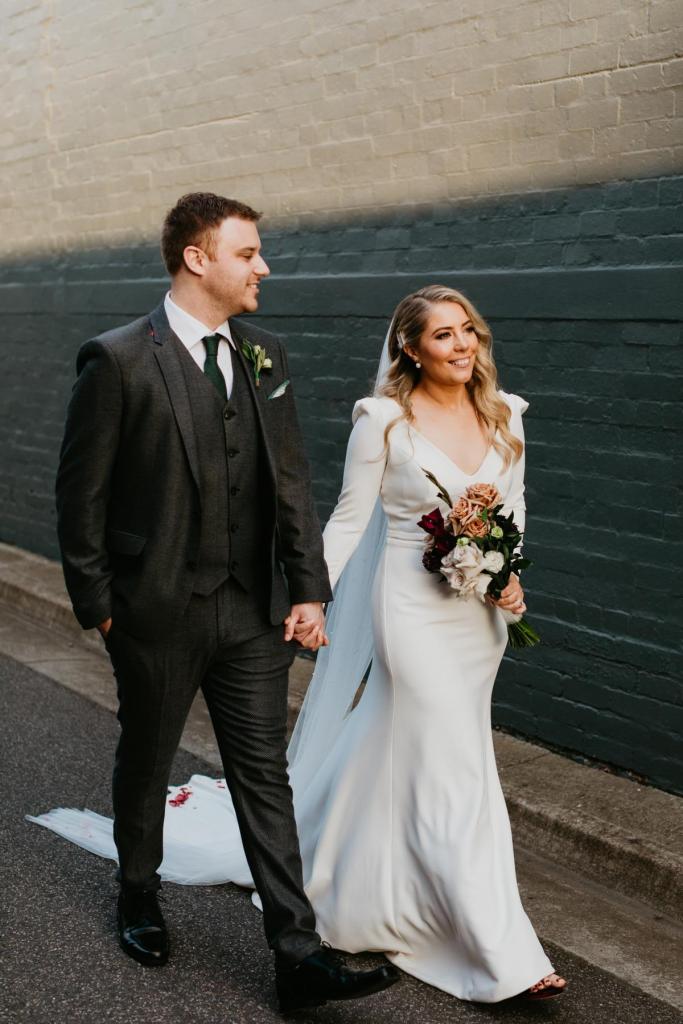 KWH bride Kara with husband Justin, wearing the AUBREY gown; a long-sleeve euphorbia wedding dress with a deep v-neck.