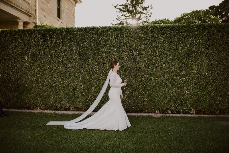 KWH bride Cassie looking elegant in her Jemma wedding dress; a bohemian wedding dress with lace sleeves and a v-neck.