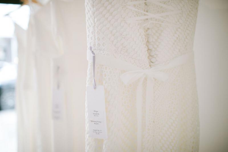 Lace wedding dress hanging on rack