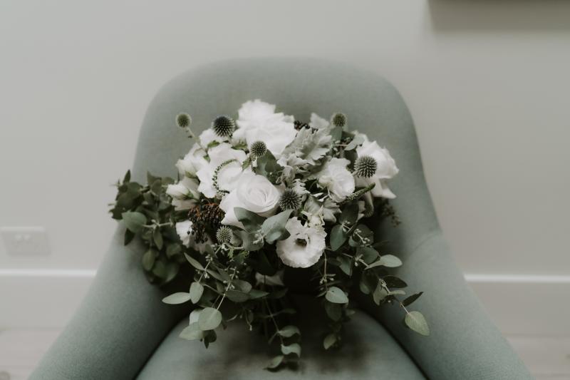 Bride Ania in Karen Willis Holmes Lola Wedding dress posing with native bridal bouquet with bridesmaids in white