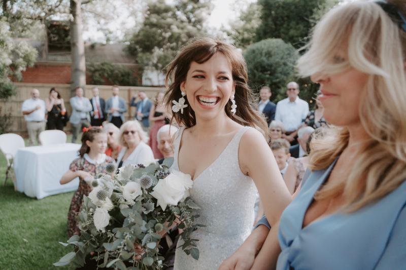 Bride Ania in Karen Willis Holmes Lola Wedding dress posing with native bridal bouquet with bridesmaids in white