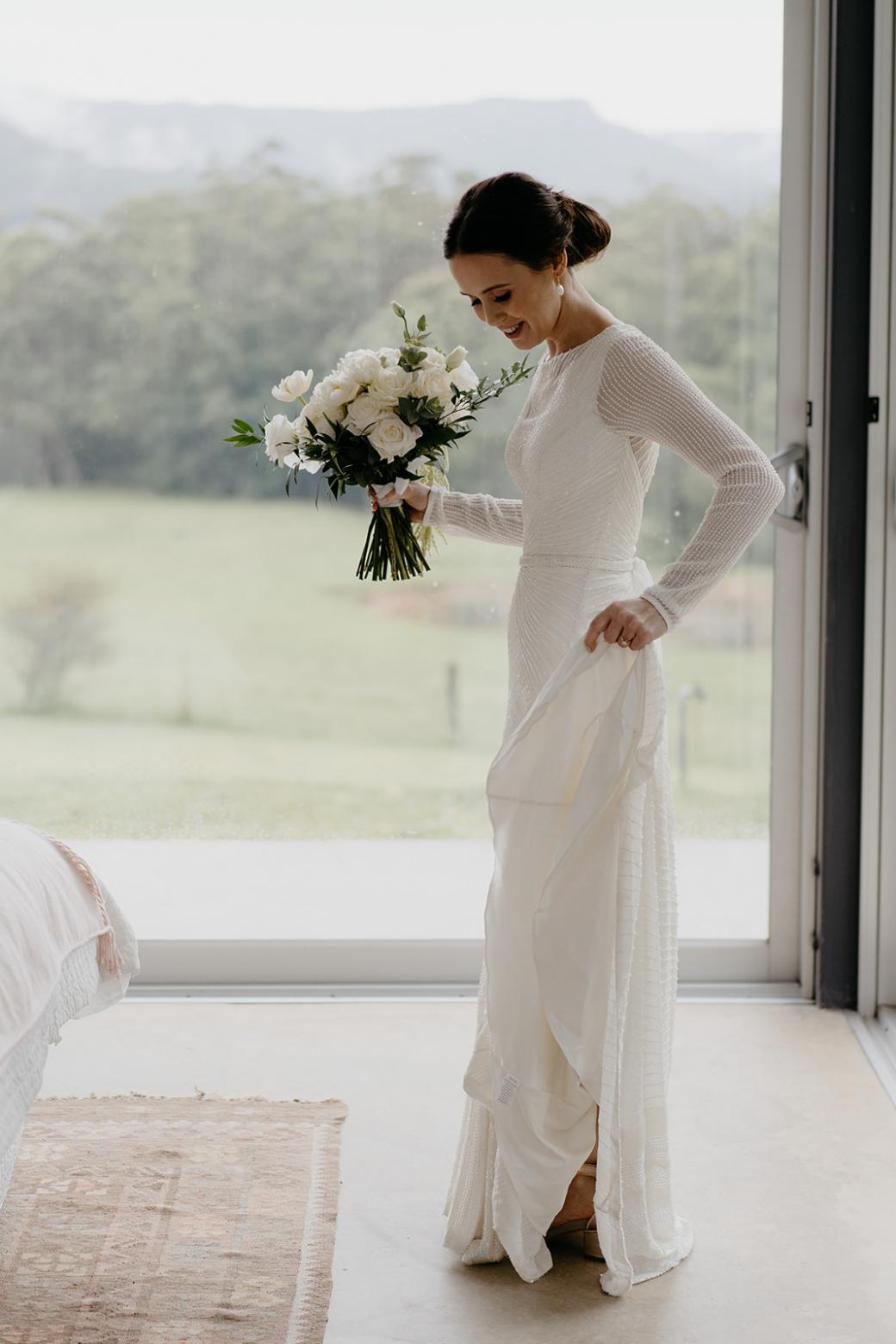 Karen Willis Holmes bride Anna wearing the Cassie wedding dress holding her white and green bouquet.