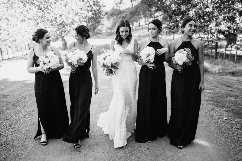 Real KWH bride Tash wears the Lola gown with Genevieve trains whilst holding a white and green foliage bouquet.