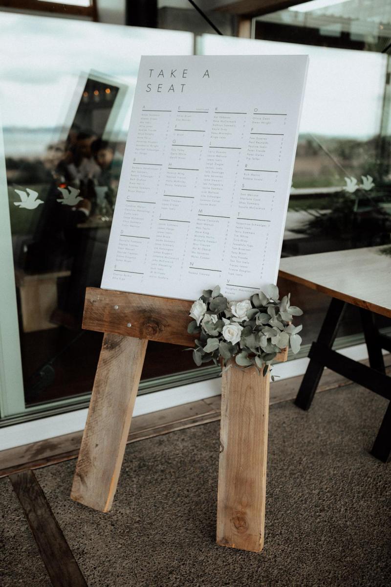 Real KWH bride Tash wears the Lola gown with Genevieve trains whilst holding a white and green foliage bouquet.