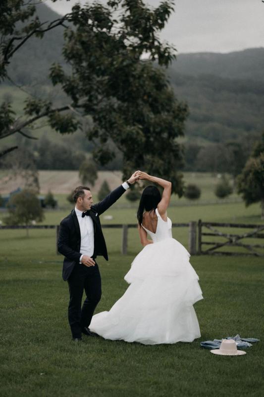 Real couple Sarah & Phil dancing at their country farm wedding, bride wears the Taryn Marina gown by Karen Willis holmes.