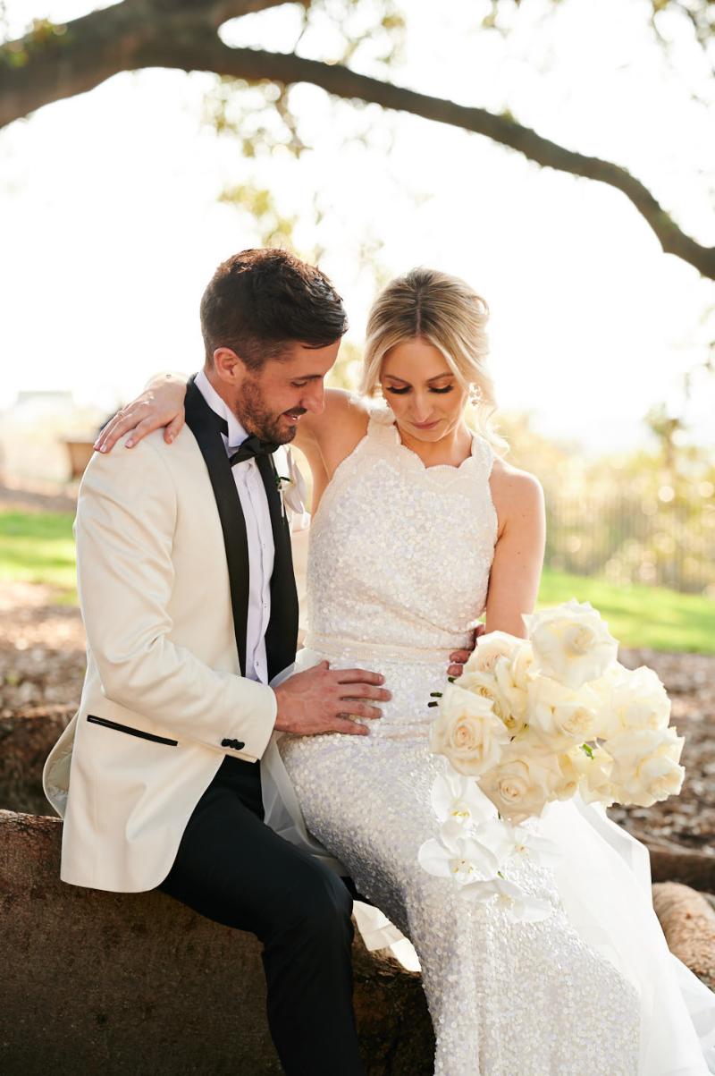 Real bride Claire wears the Cindy gown, a beaded halterneck wedding dress to her first look, Luxe dress by Karen Willis Holmes.