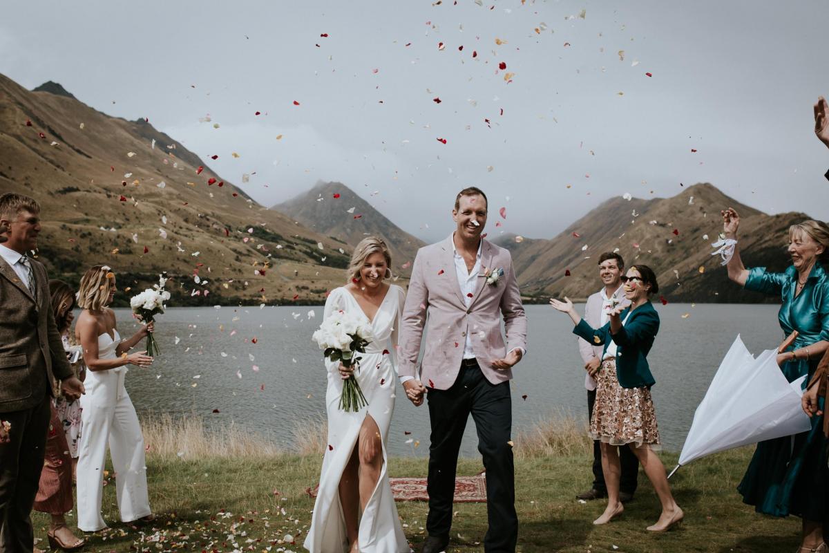 KWH bride Lauren and husband Will walking down the aisle with confetti being thrown over them. Bride wears the Nikki wedding dress.