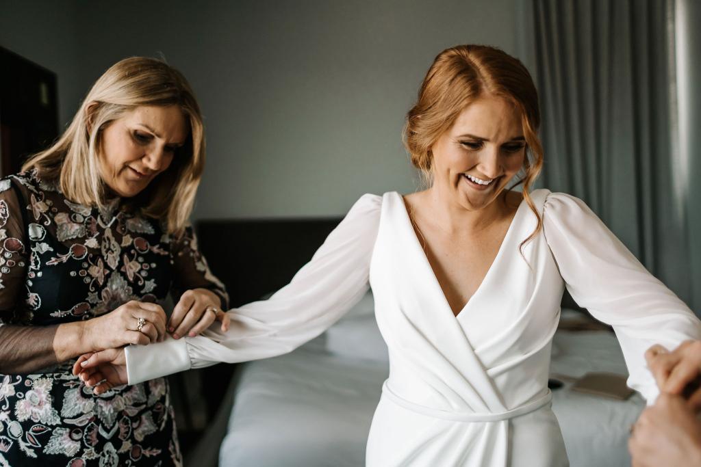 Real bride Shannon getting ready for her wedding day, wearing the long sleeved Nikki gown, an elegant wedding dress by Karen Willis Holmes.