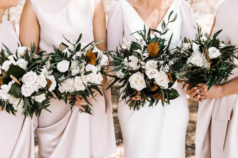 Real bride Shannon and her bridesmaids holding their bridal bouquets; featuring white roses and native Australian flora.