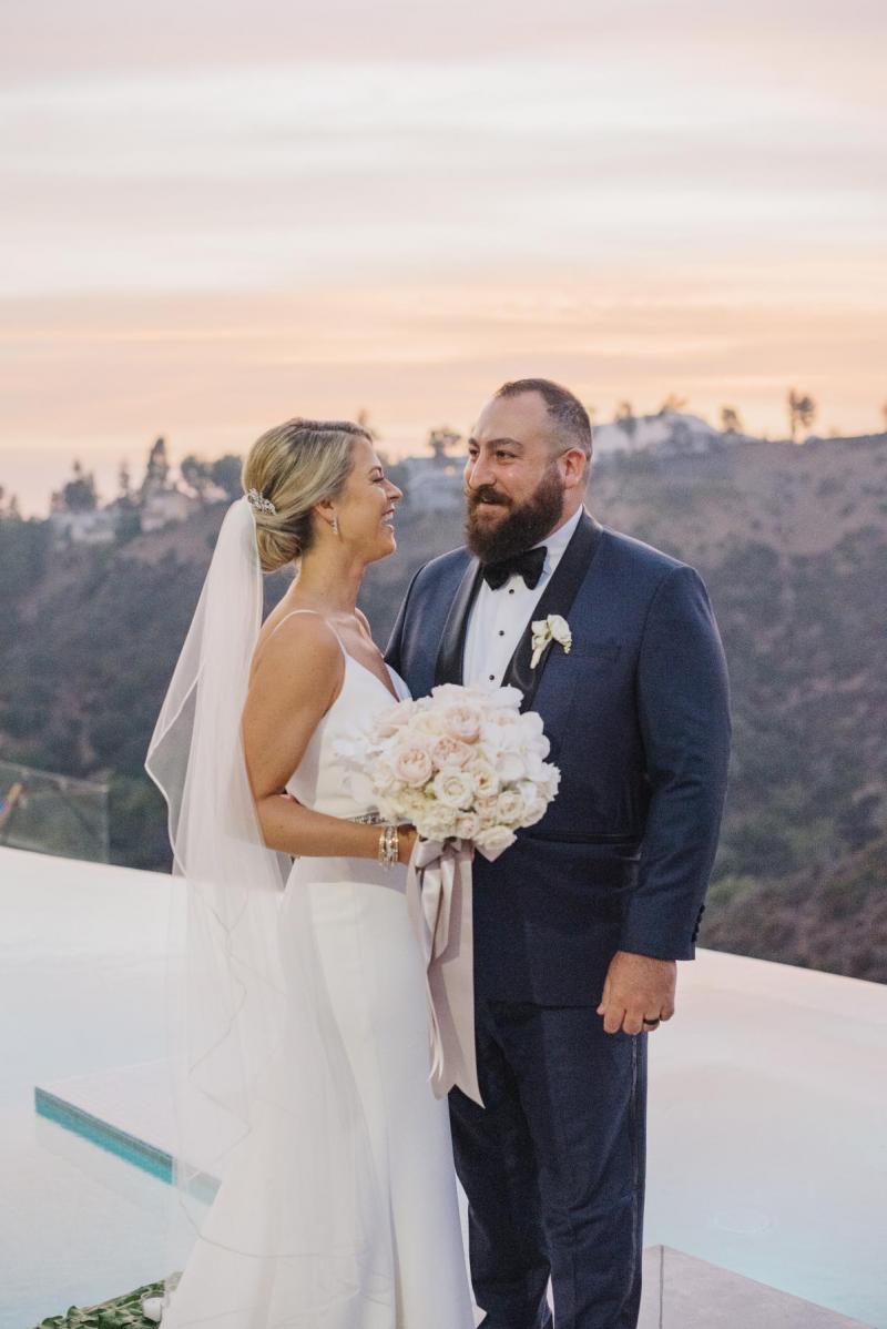 Real bride Noel wears the Caroline gown; a simple v-neck wedding dress from the Wild Hearts collection by Karen Willis Holmes to her intimate LA wedding along with simple bridal veil.