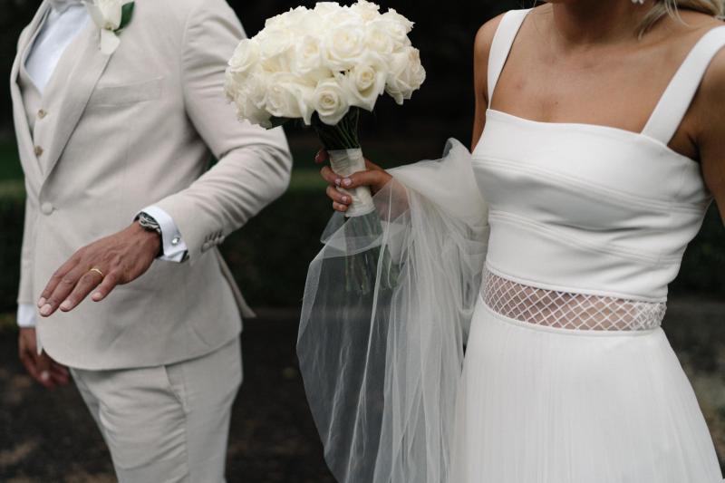 Real bride Maddi wears the Daisy gown, a non-conventional wedding dress with a pleated skirt and panel waist by Karen Willis Holmes, bride wearing a long veil.