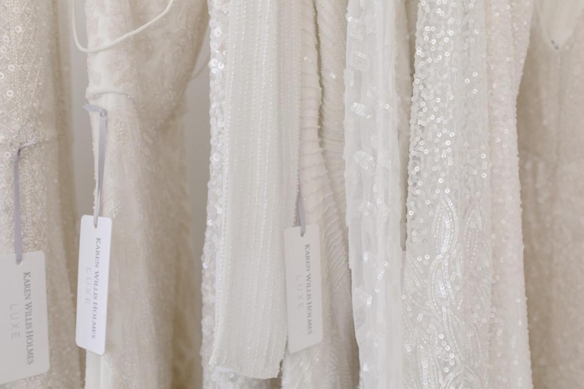 Karen Willis Holmes 20th Anniversary of Australian bridal picture of LUXE beaded wedding dresses hanging on rack