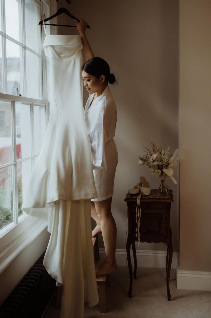 KWH bride Bonita getting ready. Wearing the off-the-shoulder Lauren wedding dress; with an open back and button details