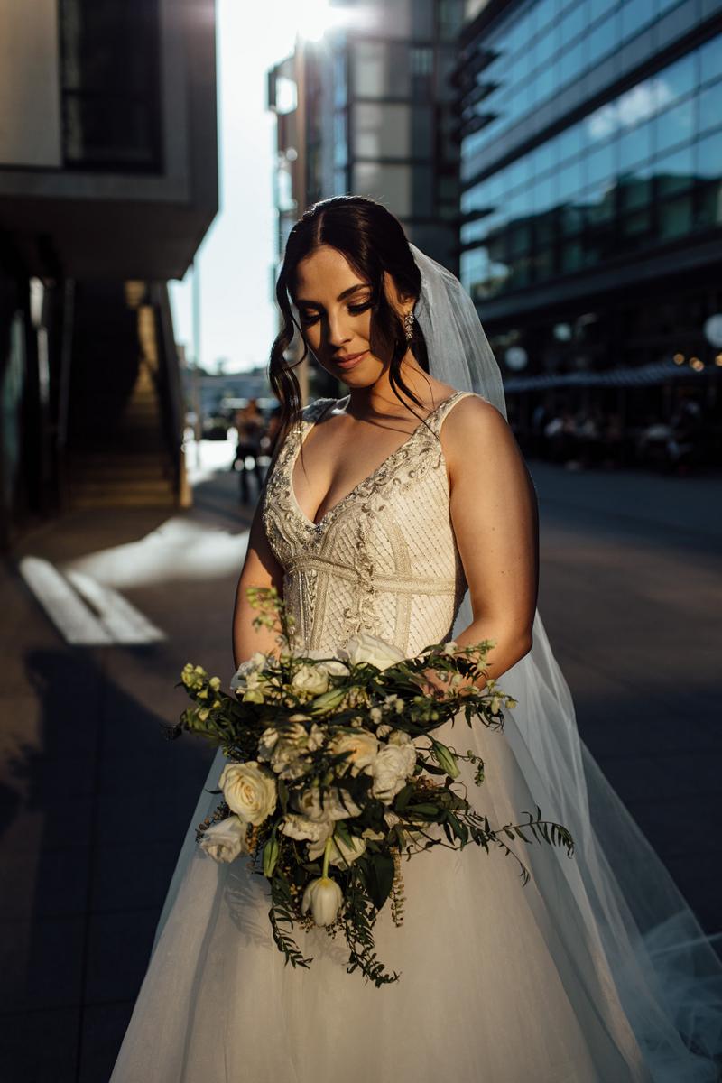 Real bride Stef wears the Sophie gown with neutral florals; a heavily embellished a-line bespoke wedding dress by Karen Willis Holmes.