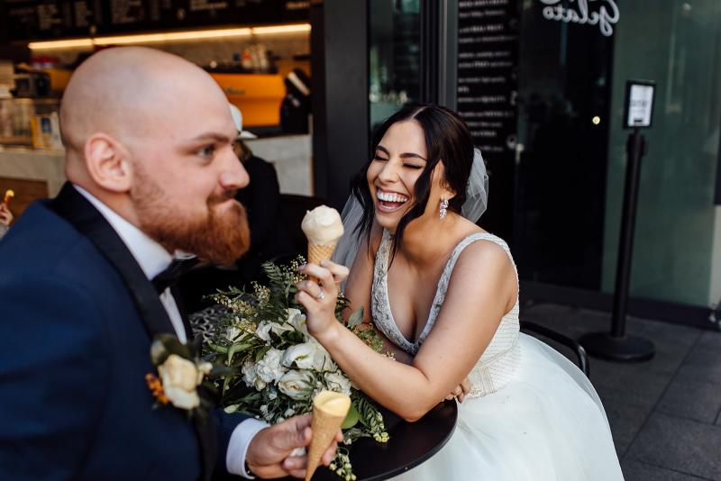 Real bride Stef and husband Josh eating ice cream after Sydney wedding, bride wears the Sophie gown by Karen Willis holmes.