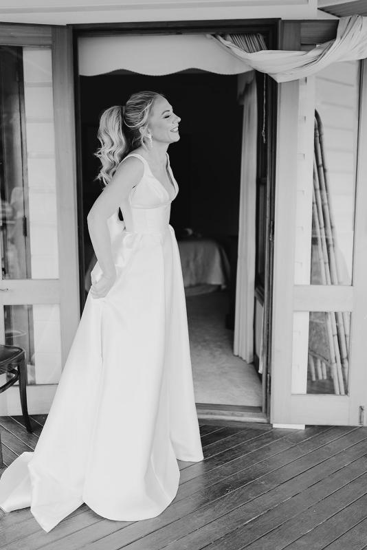 Real bride Caroline getting ready for her wedding, wearing the Taryn Camille gown with custom bow; a modern a-line wedding dress by Karen Willis Holmes.