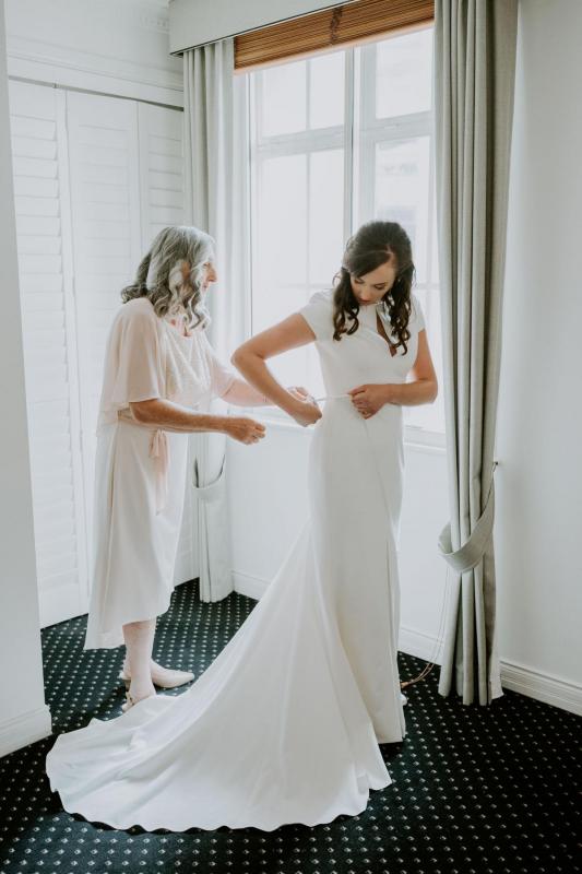 Real bride Jennifer getting ready her for real wedding, wearing the Clarissa gown, a simple cap sleeve wedding dress by Karen Willis Holmes.