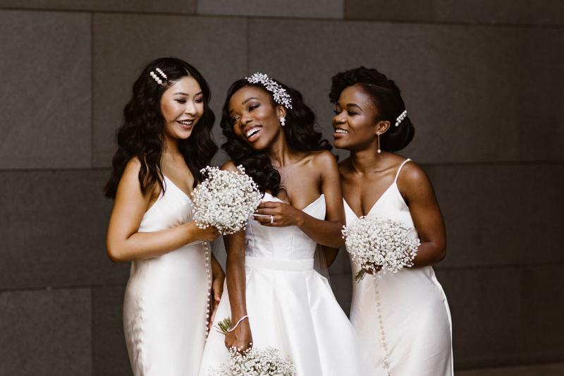 Real bride Ancille poses with bridesmaids in white, wearing the Kitty Melanie gown by Karen Willis Holmes.