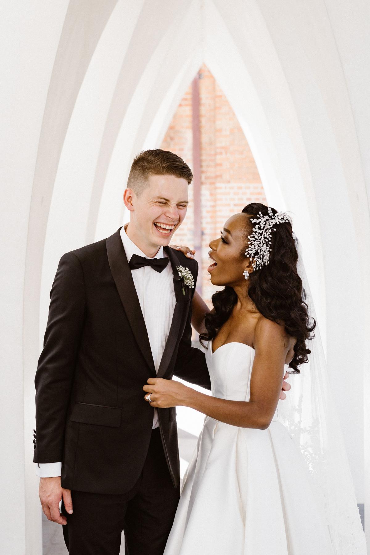 KWH real bride Ancille laughs with her new husband Dar at the curch. She wears the unqie Kitty Melanie gown from KWH.