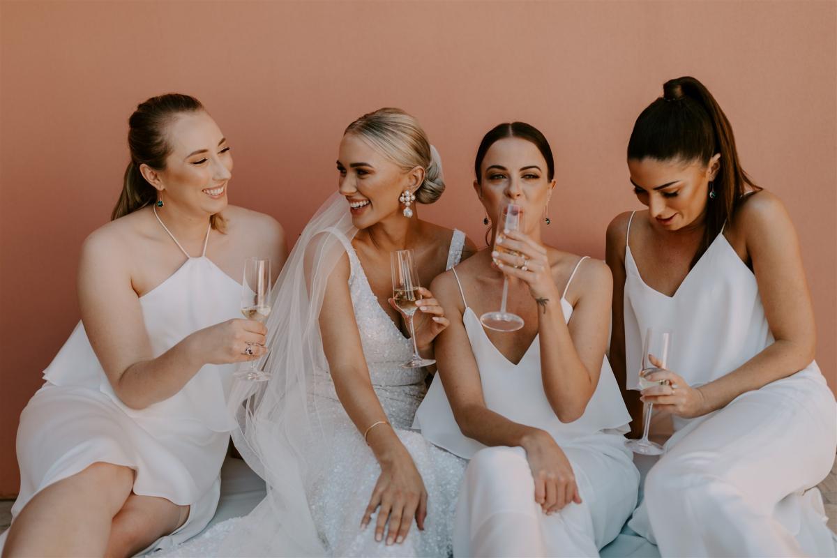 Real bride Shannon posing with her bridesmaids at her intimate small covid wedding, wearing the Lola ogwn by Karen Willis Holmes.