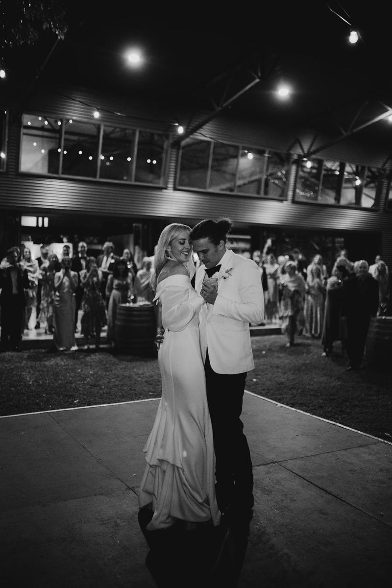 Real bride Hannah dancing with husband at small wedding ceremony, wearing the Lauren gown by Karen Willis Holmes.