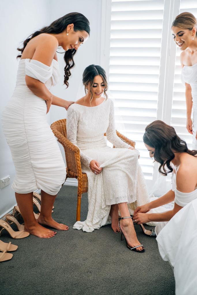 Real bride Katrina getting ready for wedding with bridesmaids, wearing the Margareta gown, a long sleeve backless wedding dress Karen Willis Holmes.