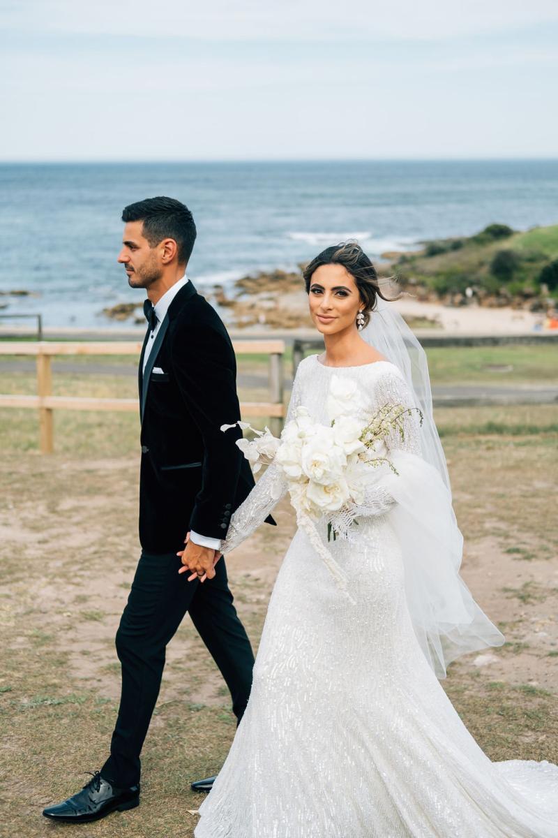 Real bride Katrina wears the Margareta gown, a long sleeve wedding dress by Karen Willis Holmes, to intimate small beach wedding