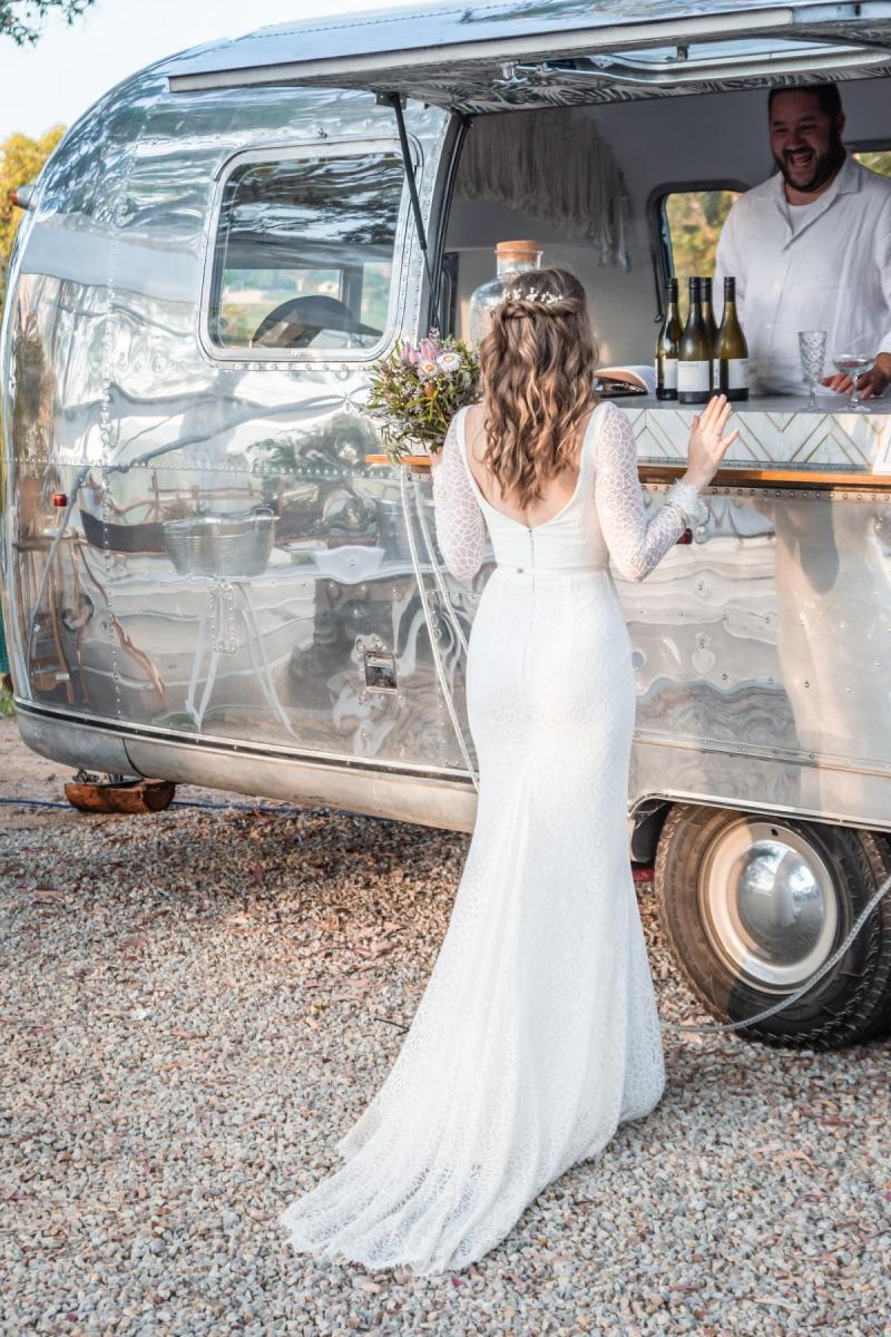 Real bride Monica enjoying her reception food truck at small wedding reception, wearing the Rylie gown by Karen Willis holmes.