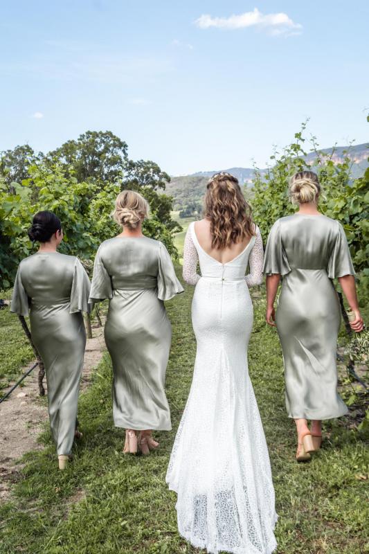 Real bride Monica wears the Rylie gown; a long sleeve lace wedding dress by Karen Willis Holmes with her mint green bridesmaid dresses.