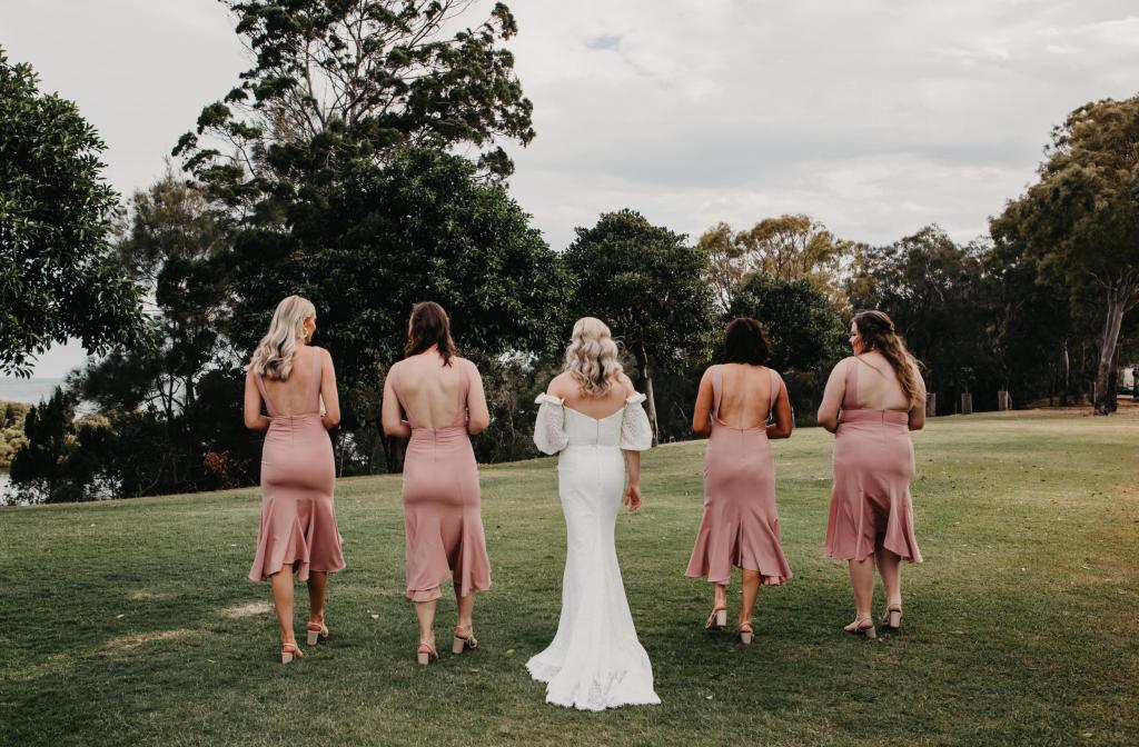 Real bride Kacie-Lee poses with bridesmaids wearing blush dresses, bride wearing the Vivienne gown by Karen Willis Holmes.