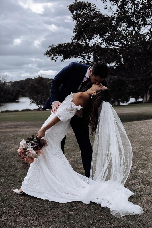 Real bride Zinovia getting swept off her feet with husband at rustic country wedding, wearing the Vivienne wedding dress by Karen Willis Holmes.