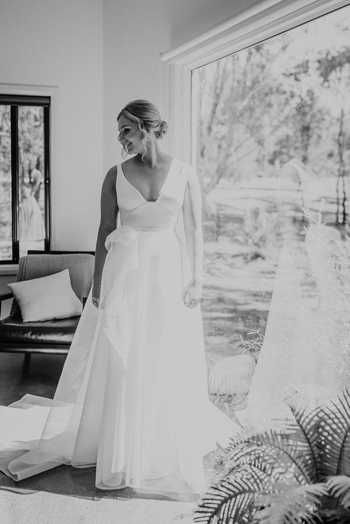 Real bride Samantha getting ready for her wedding, wearing the Aisha gonw; a v-neck A-line wedding dress with floral details by Karen Willis Holmes.