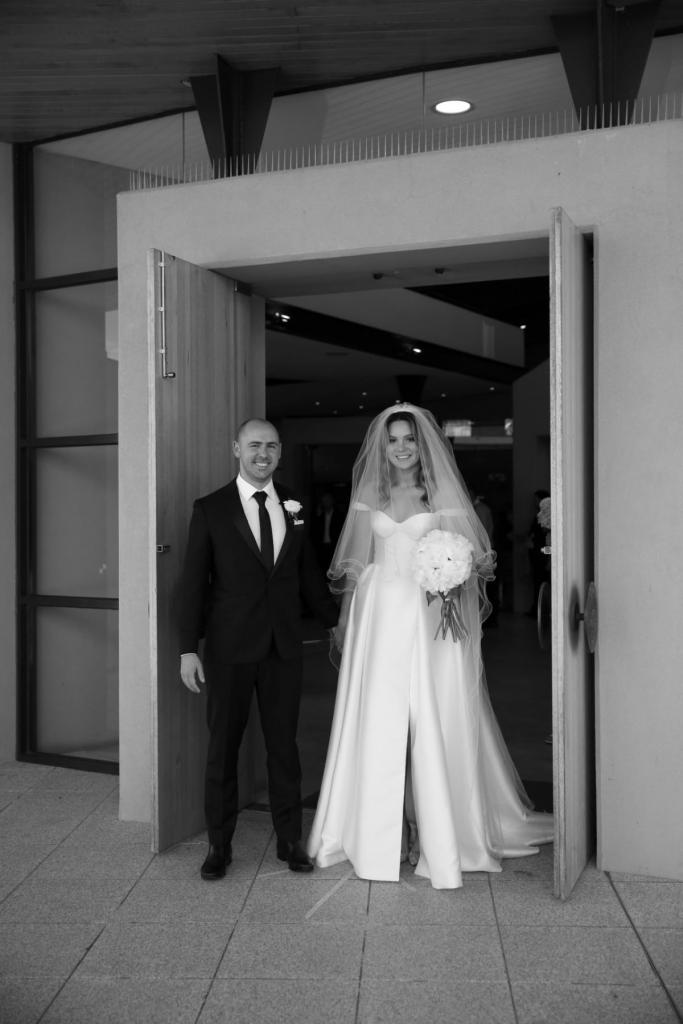 Real bride Valentina poses with husband wearing the Blake Camille gown; a traditional-style sweetheart wedding dress by Karen Willis Holmes with dramatic veil.