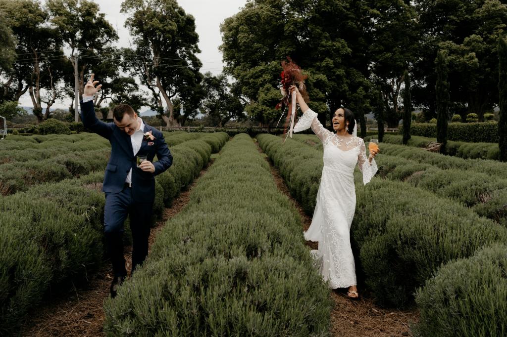 Real bride Saliya with husband at garden wedding, wearing the Pascale gown and Lucienne veil; a long sleeve boho lace wedding dress by Karen Willis Holmes.