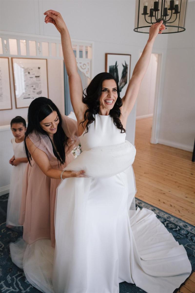 Real Bride Marianne getting ready for her Sydney wedding wearing the Bridget gown & Lea Skirt; a simple halter neckline wedding dress with pearl skirt overlay by Karen Willis Holmes.