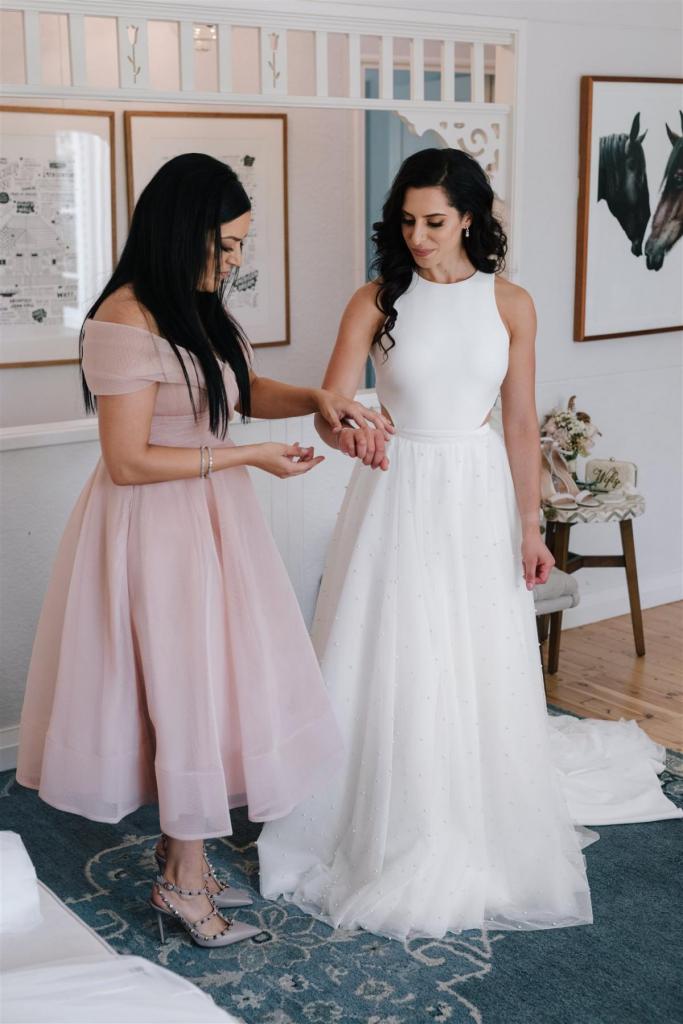Real Bride Marianne getting ready for her Sydney wedding wearing the Bridget gown & Lea Skirt; a simple halter neckline wedding dress with pearl skirt overlay by Karen Willis Holmes.