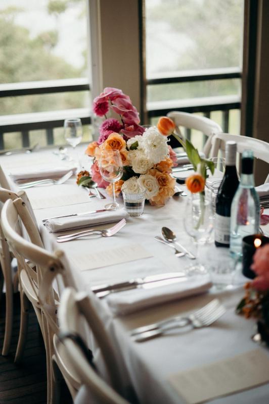Real bride Riley's reception table decorated with vibrate orange and pink florals from Boutierre Girls at the Burnt Orange Mosman.