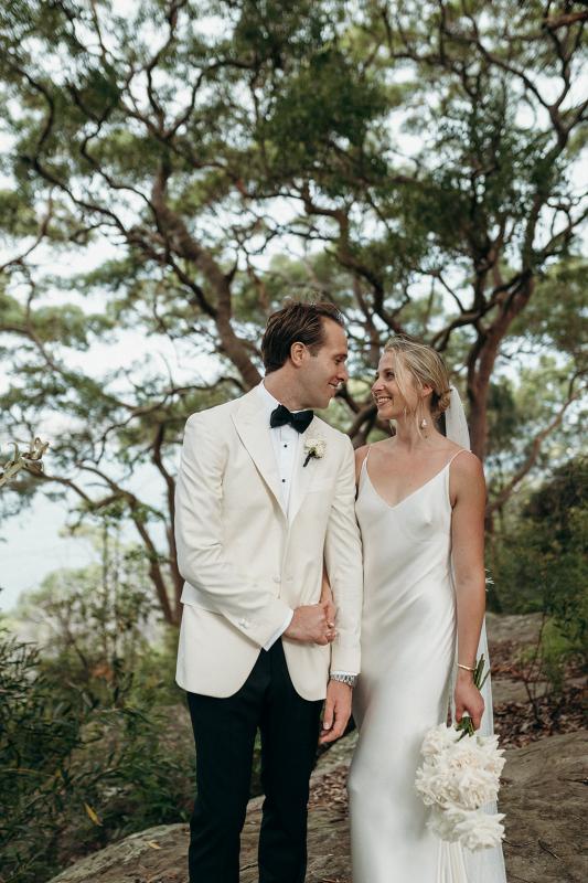 Real bride Riley and Wes look longingly into each other's eyes as Riley wears her contemporary Sage wedding dress by KWH.