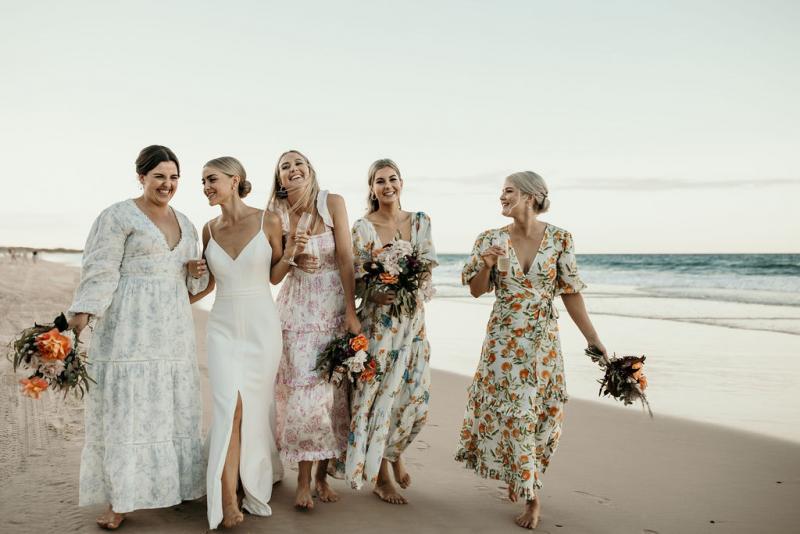 Real bride Kate with her bridesmaids at beach wedding, wearing the Caroline gown; a simple v-neck wedding dress by Karen Willis Holmes with a sweetheart neckline.