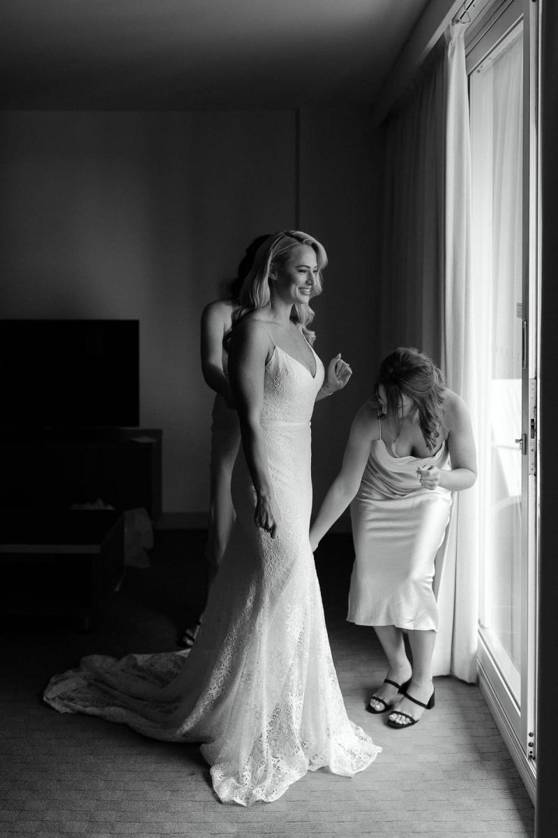 KWH real bride Nicole standing in front of the window in her fit and flare Justine gown.