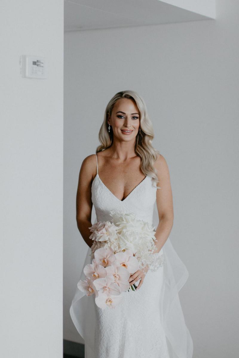 KWH real bride Nicole stands in her Justine gown with her blush orchid bouquet by Ellebore.