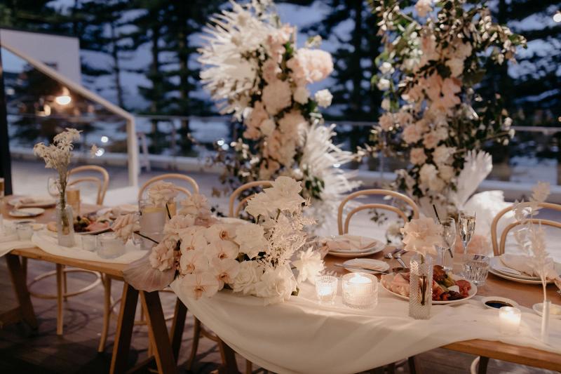 Real bride Nicole's white wedding cake with blush and white florals decorating it made by Art of Baking.