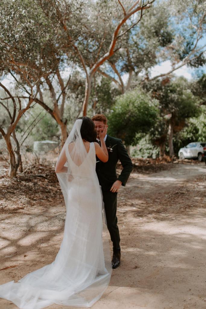 Real bride Amber and Stewart at their first look in the middle of a gumtree forest. She wears the Olympia sequin and beaded gown from KWH.