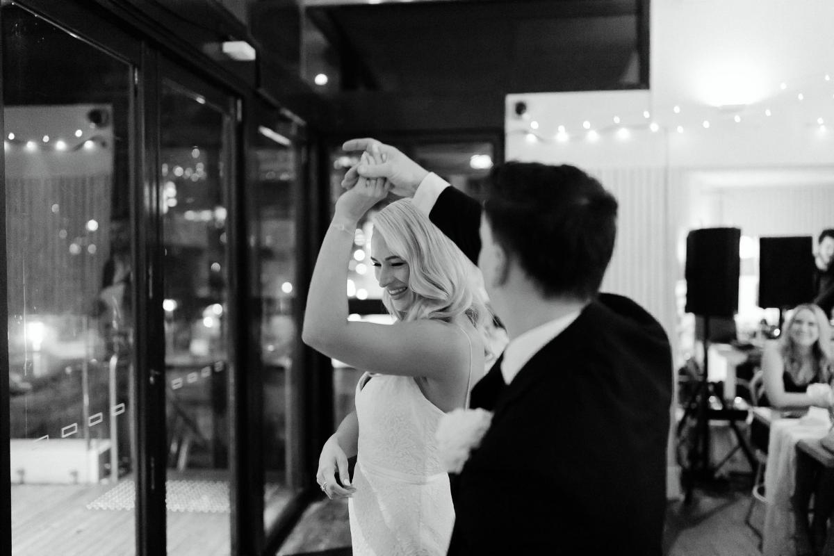 KWH real bride Nicole and Chris have their first dance. She appears in the delicate lace Justine gown with a front split.