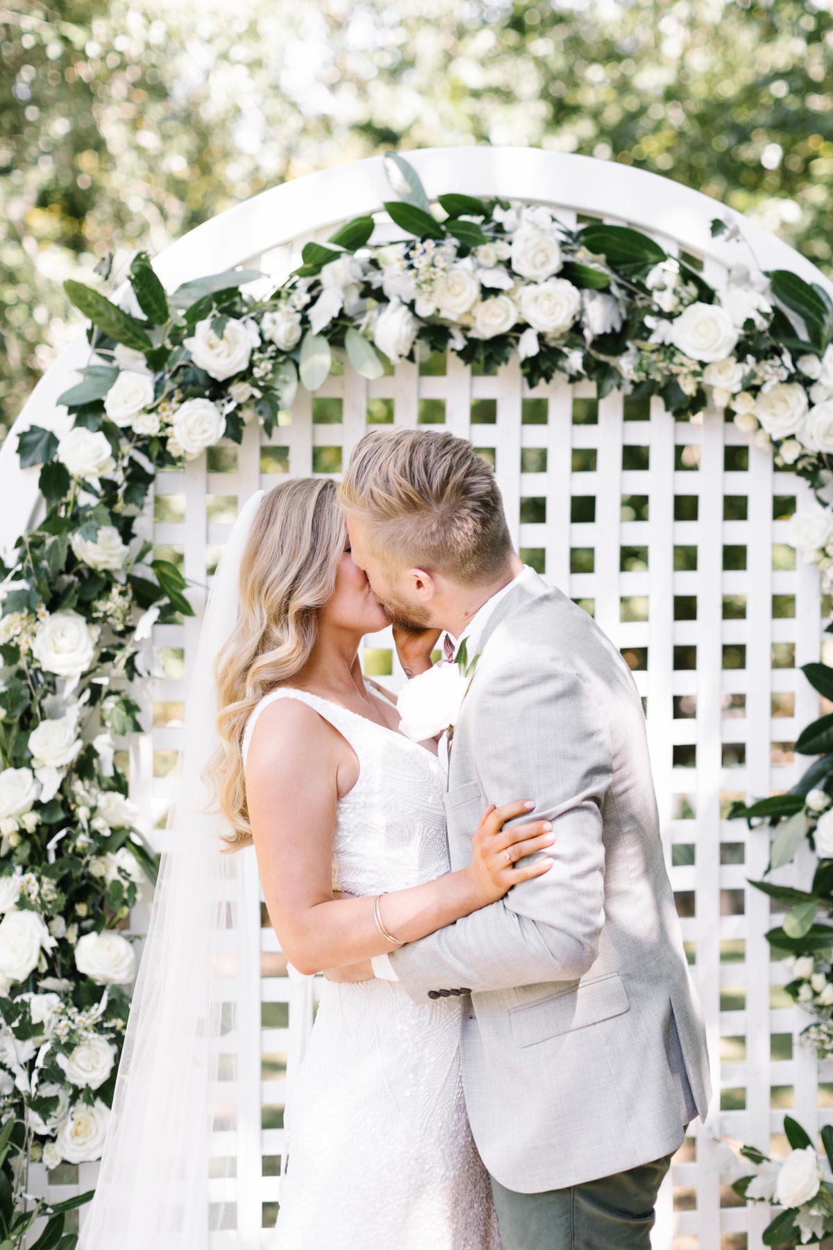 KWH real bride Bec and Nick have their first kiss at the alter. She wears the timeless Olympia gown with v-neck.