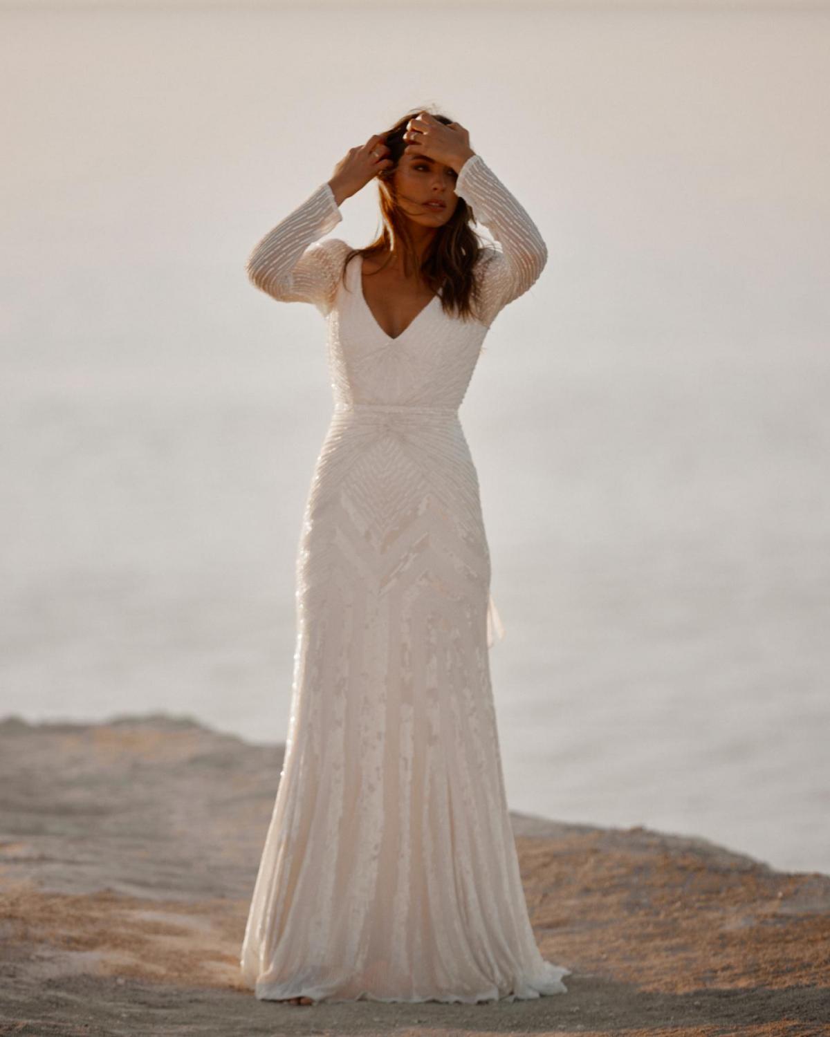 The Perry gown by Karen Willis Holmes, a V-Neck long sleeve beaded wedding dress with a fit and flare shape.