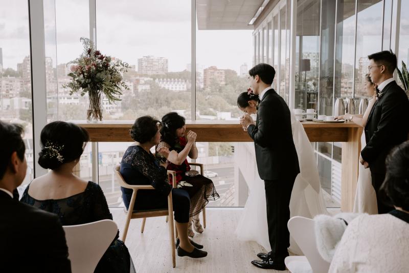 KWH real bride Sarah and Brian bowing to their mothers for their tea ceremony. She wears the traditonal Kitty Joni gown.